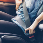 A person buckling their seatbelt